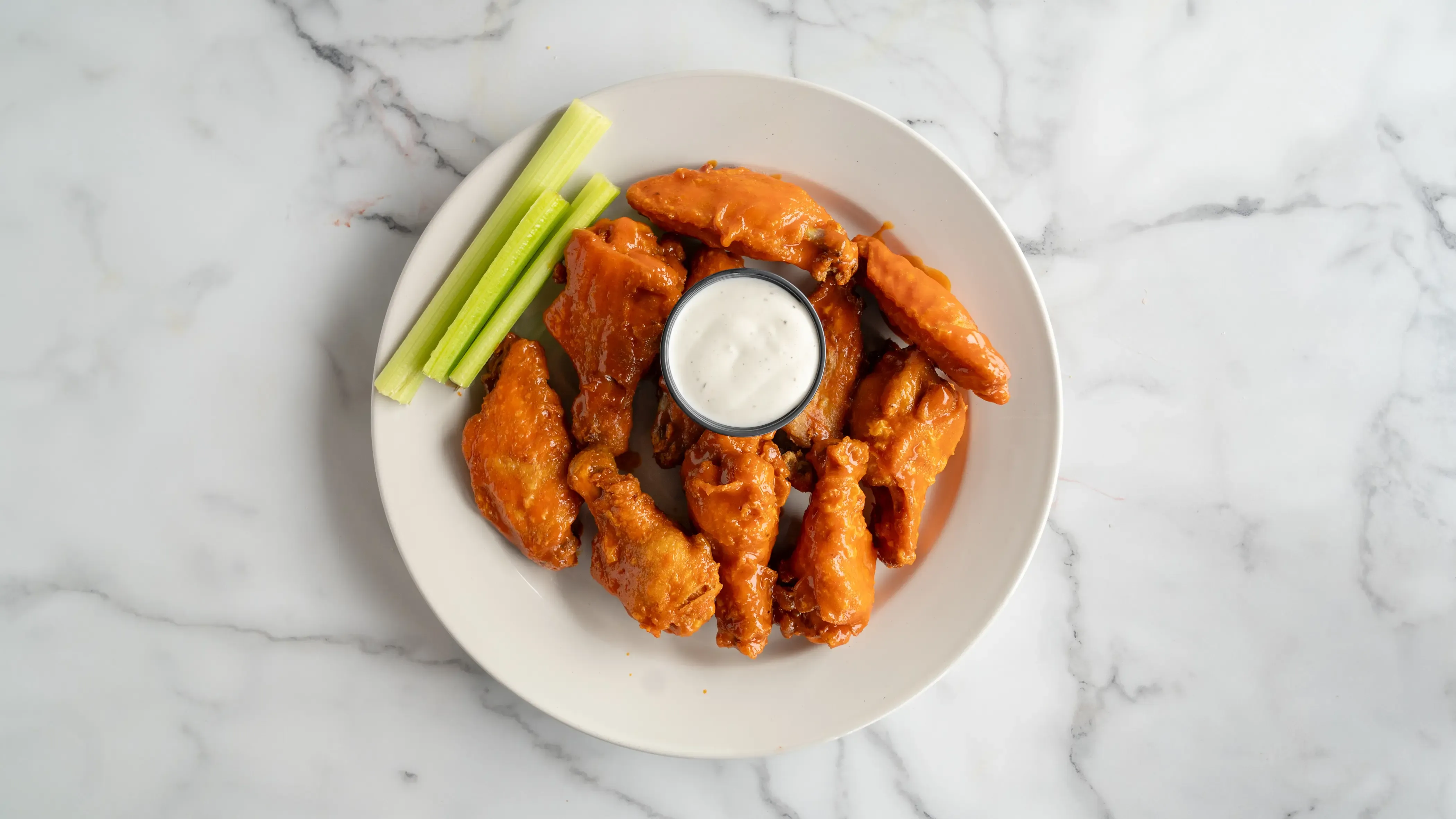 Ten crispy chicken wings tossed in your choice of sauce: BBQ, buffalo, or mango habanero. Served with celery sticks and ranch or blue cheese dressing